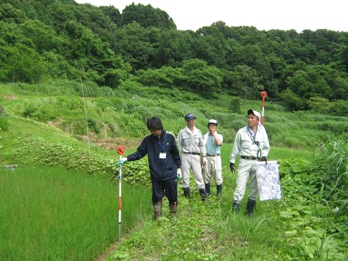 測量作業を行う新潟大学の学生と地元住民の画像