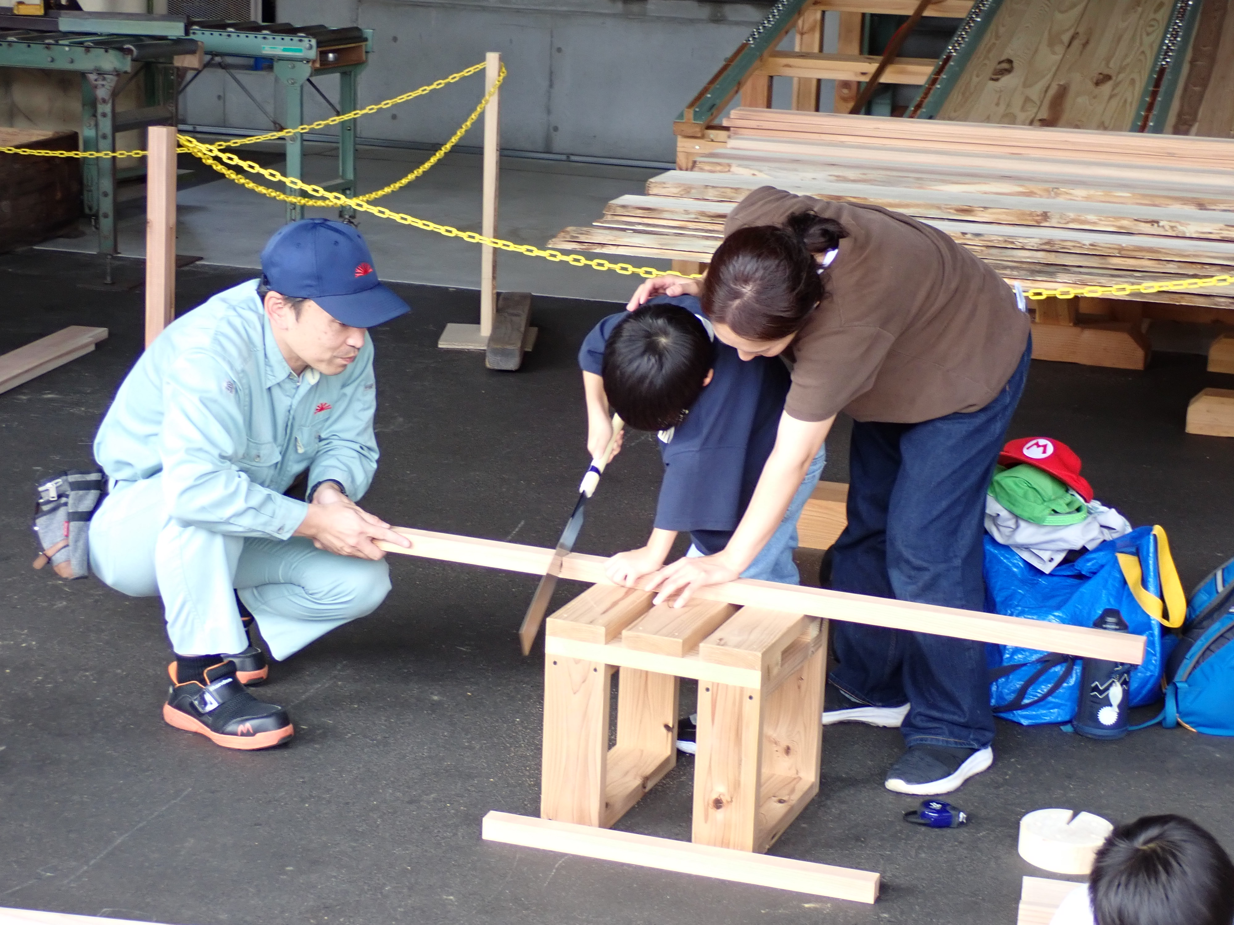 木材をのこぎりで切る作業