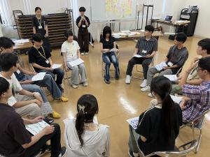 車座になって一人ずつ発表をしている様子
