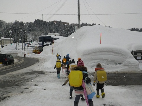除雪された歩道を使って通学する子供たちの画像